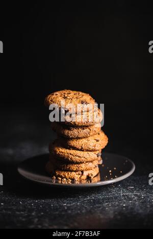 Pile de biscuits savoureux au chocolat. Biscuits au chocolat doux sur table noire. Banque D'Images