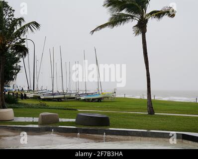 Petits yachts à voile sur des remorques garés sur l'herbe à côté du l'océan par une journée humide et venteuse Banque D'Images