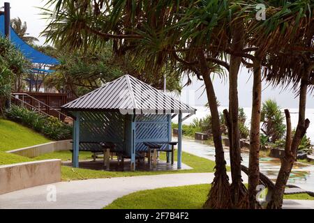 Cadre de pique-nique à l'ombre à côté d'un sentier de randonnée en bord de mer dans un paysage jardins Banque D'Images