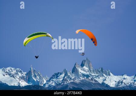 Parapentes survolant les montagnes au soleil Banque D'Images