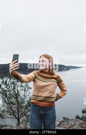 Smiling young woman taking selfies Banque D'Images