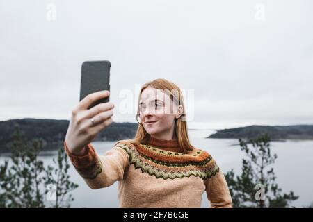 Smiling young woman taking selfies Banque D'Images