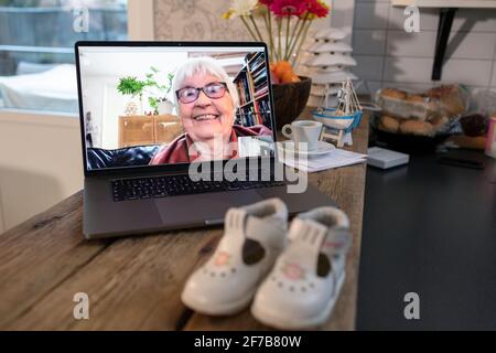 Femme âgée souriante sur l'écran d'un ordinateur portable Banque D'Images
