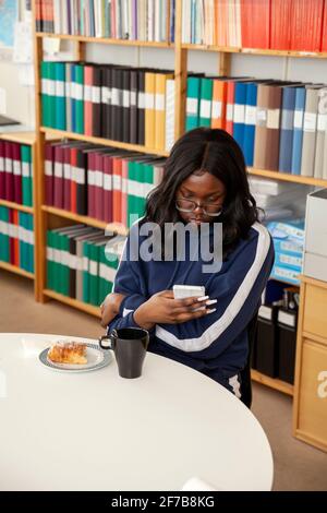 Femme avec smartphone au bureau Banque D'Images