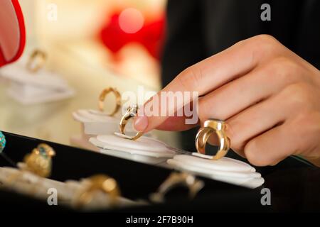 Couple - seule main de femme à voir - choisir des anneaux de mariage à un bijoutier Banque D'Images