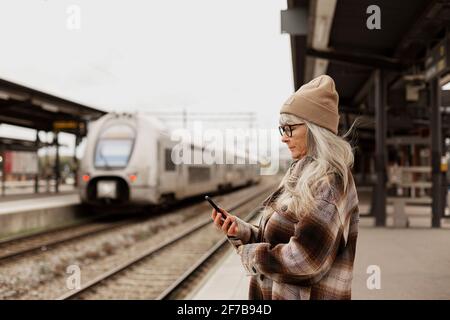 Femme mature à la gare Banque D'Images