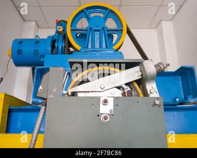 La grande roue circulaire du moteur de l'élévateur passager dans la salle de contrôle située en haut du bâtiment, centrée de manière sélective sur la première roue circulaire, Banque D'Images