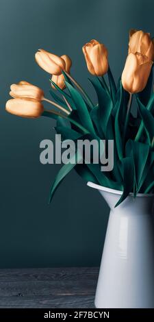 Tulipes dans une carafe. Classique encore vie avec un bouquet de fleurs de tulipe délicates dans un pot blanc vintage sur un fond vert et une vieille table en bois. Art Banque D'Images