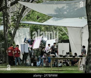 Ho Chi Minh ville, 21 mars 2021: L'équipe de film Covid-19 portant des masques faisant la préparation des coulisses sur le plateau avec l'équipement pour filmer en extérieur dans le parc. Banque D'Images