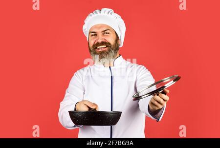 Poêle de haute qualité. Homme barbu cuisinier blanc uniforme. Petit-déjeuner maison. Cuisiner comme un pro. Repas savoureux et facile préparés à la maison. Récipient en céramique Banque D'Images