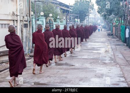 Moines marchant dans les rues de Bago collectant des dons alimentaires, Bago, Myanmar Banque D'Images