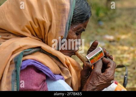 Chattikona, Inde - février 2021 : une femme d'Adivasi de la tribu Desia Kondh fume sur le marché de Chétikona le 17 février 2021 à Odisha, Inde. Banque D'Images