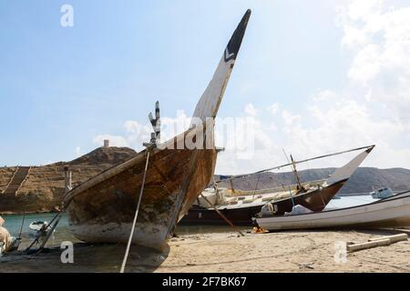 Des huws beached sur la plage de sur, Oman. Tour de guet d'Ayjah en arrière-plan Banque D'Images