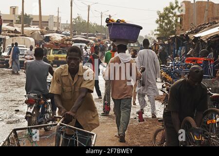 Scène Grand marche, Man porte un grand bol avec des jouets sur sa tête au marché à Bamako, Mali, Afrique de l'Ouest. Banque D'Images