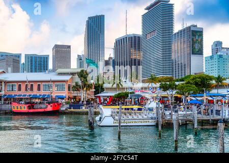 Bayside Marketplace à Miami avec des bateaux d'excursion amarrés et des gratte-ciel modernes s'élevant derrière le front de mer, Floride, États-Unis Banque D'Images