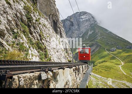 Train à crémaillère traversant le paysage montagneux des Alpes suisses. Train rouge sur train à crémaillère entre le Mont Pilatus et Alpnachstad près de Lucerne. Banque D'Images