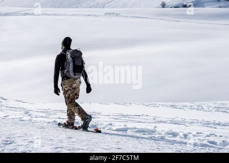 Randonnée en raquettes de randonneurs mâles non reconnaissables dans un paysage hivernal enneigé sur le plateau de Lessinia (Altopiano della Lessinia), station de ski de Malga San Giorgio, Vérone Banque D'Images