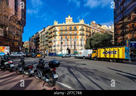 Trafic urbain dans la rue entre les bâtiments sous ciel bleu à Barcelone - capitale et plus grande ville de Catalogne, Espagne. Banque D'Images