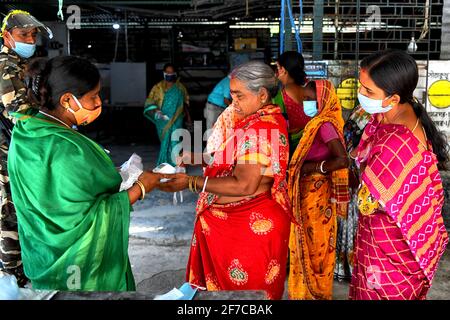 Un professionnel de la santé vérifie la température corporelle d'un électeur lors de l'élection de l'Assemblée législative du Bengale occidental de 2021 à Baruipur. (Photo par Avishek Das / SOPA Images / Sipa USA) Banque D'Images