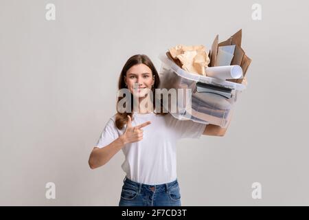 Recyclage des déchets de papier. Conteneur en plastique de retenue pour femme millénaire rempli de déchets en carton Banque D'Images