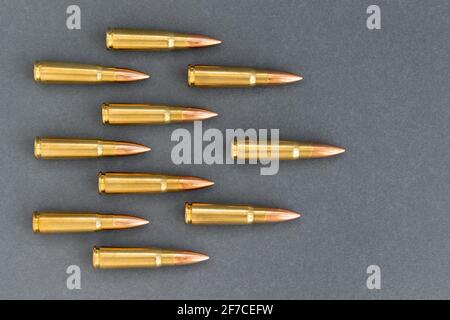 Puces sur fond de papier gris. Cartouches calibre 7.62 pour fusil d'assaut Kalachnikov Banque D'Images