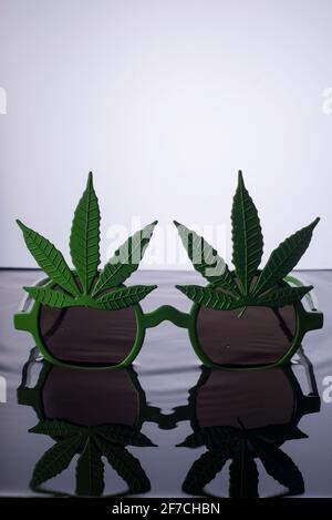 lunettes de soleil sur l'eau annonçant photo vert lunettes de soleil avec des éléments de feuille de marijuana, isoler sur fond blanc Banque D'Images