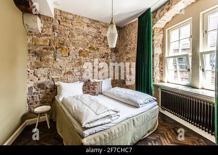 Chambre double simple et belle avec de nombreux matériaux naturels. Au centre, le lit de luxe de Coco-Mat vous offre un sommeil réparateur. Hotel Renthof, Kassel, Allemagne Banque D'Images