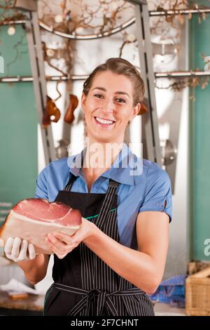 Portrait of smiling butcher magnifique avec de la viande crue Banque D'Images