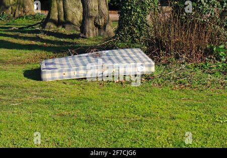 Un matelas à bout de mouche sur un petit vert dans un quartier résidentiel du Borough de Hellesdon, Norfolk, Angleterre, Royaume-Uni. Banque D'Images