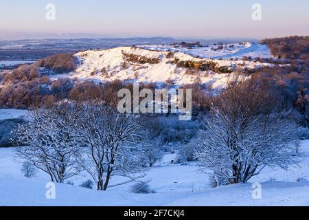 Début de l'hiver, neige sur Crickley Hill vue depuis Barrow Wake. Crickley Hill était le site de campements néolithiques et de forts de colline de l'âge du bronze et de l'âge du fer. Banque D'Images