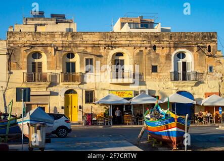 Marsaxlokk, Malte, 28 févr. 2020. Bâtiment maltais traditionnel au port de Marsaxlokk pendant le coucher du soleil. Banque D'Images