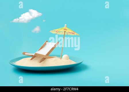 Plage tropicale concept fait de plaque avec sable, chaise de pont et parasol. Concept de vacances d'été créatif Banque D'Images