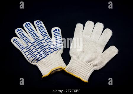 Nouveaux gants de travail avec couche de protection en caoutchouc pour la construction et réparer sur fond noir Banque D'Images