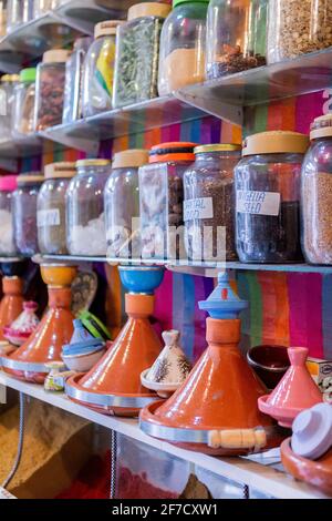 Des bocaux aux épices et aux tagines sur une étagère dans une boutique de la médina de Marrakech, au Maroc Banque D'Images