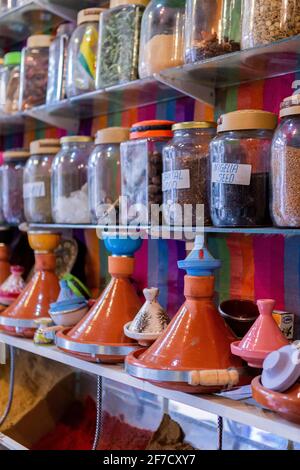 Des bocaux aux épices et aux tagines sur une étagère dans une boutique de la médina de Marrakech, au Maroc Banque D'Images