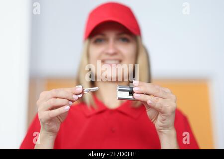 Femme souriante tenant la clé et le cadenas près Banque D'Images