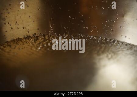 Bol de chant tibétain plein d'eau gros plan sur les gouttes d'eau, instrument de guérison sonore Banque D'Images