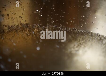 Bol de chant tibétain plein d'eau gros plan sur les gouttes d'eau, instrument de guérison sonore Banque D'Images
