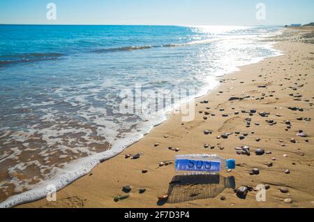 La contamination en plastique de la mer. Message SOS dans une bouteille en plastique au bord de la mer. Banque D'Images