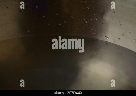 Bol de chant tibétain plein d'eau gros plan sur les gouttes d'eau, instrument de guérison sonore Banque D'Images