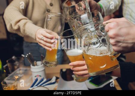 Quatre amis avec une bière fraîche dans un jardin de bière gros plan sur la bière stein Banque D'Images