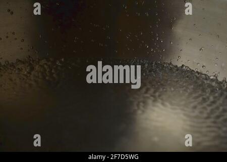 Bol de chant tibétain plein d'eau gros plan sur les gouttes d'eau, instrument de guérison sonore Banque D'Images