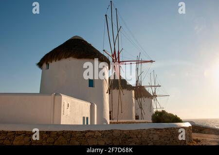 Vieux moulins à vent blancs et murs en pierre sur la côte de l'île de Mykonos en Grèce. En arrière-plan se trouve le ciel bleu. Concept vacances de voyage Banque D'Images