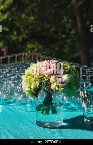 Bouquet de fleurs, champagne et verres à vin sur une table décorée lors de la réception de mariage. Dégustation de vins. Banque D'Images