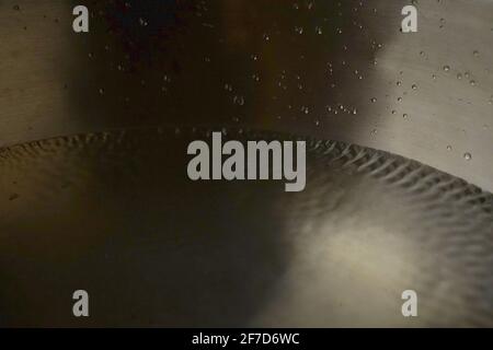 Bol de chant tibétain plein d'eau gros plan sur les gouttes d'eau, instrument de guérison sonore Banque D'Images