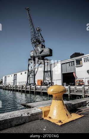 Grue de port et bollard jaune sur la côte de Wellington, Nouvelle-Zélande Banque D'Images