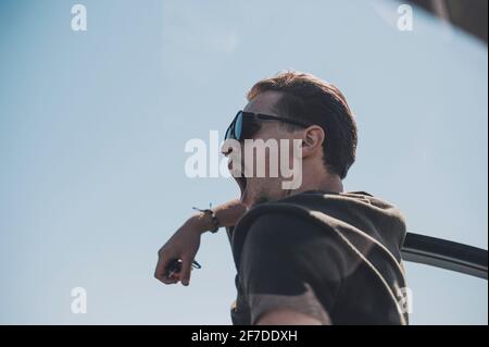 Jeune homme à l'ancienne dans des lunettes nawns près de la voiture Banque D'Images