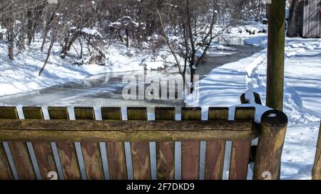 Chaise à bascule en bois de cèdre - conçue pour l'extérieur - bascule d'avant en arrière pendant un hiver matin de février dans le sud-ouest de l'Ontario, Canada. Banque D'Images