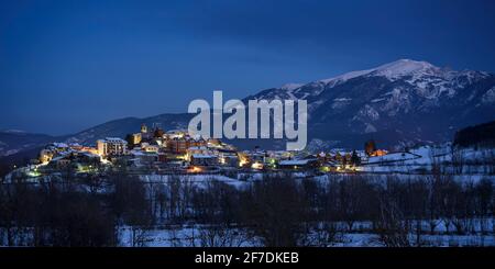 La montagne de Tosa d'Alp et le village de Bellver de Cerdanya au crépuscule enneigé de l'hiver - heure bleue (Catalogne, Espagne, Pyrénées) Banque D'Images
