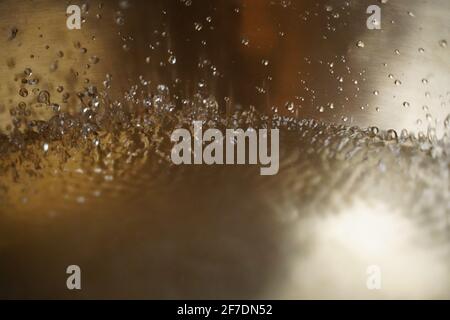 Bol de chant tibétain plein d'eau gros plan sur les gouttes d'eau, instrument de guérison sonore Banque D'Images